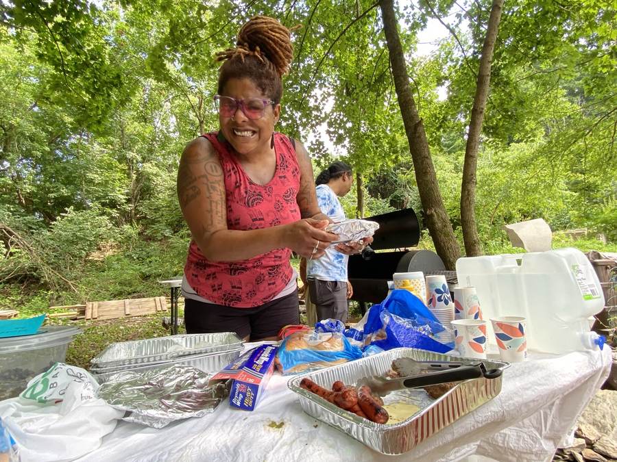 Food laid out on tables under the trees at a Sanctuary gathering