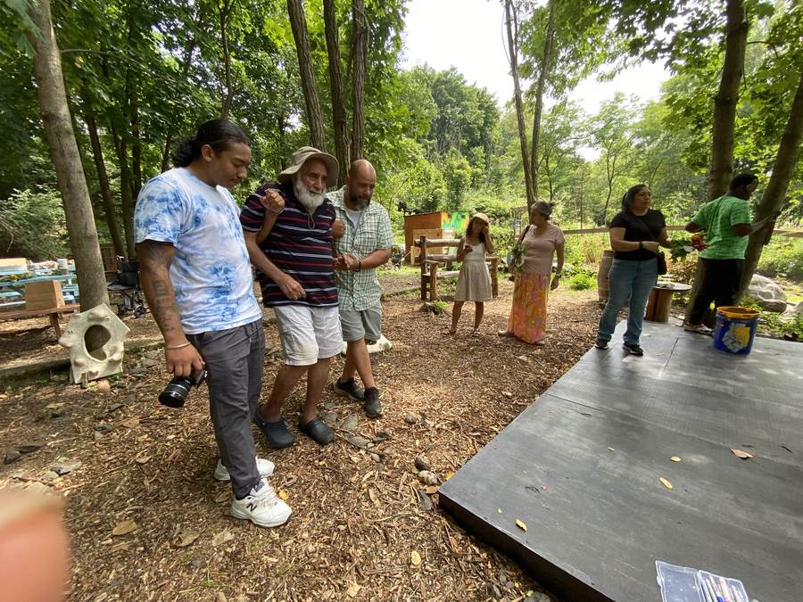 Community members gathered with tote bags beside tables at the Sanctuary