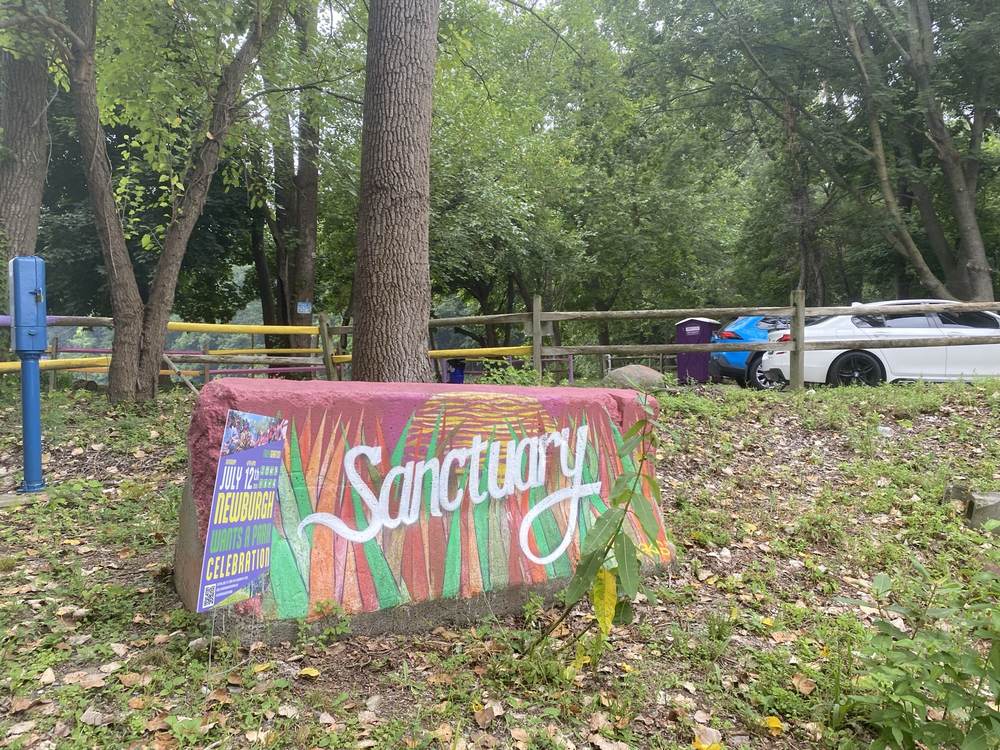 A hand-painted Sanctuary sign at the edge of the garden beds
